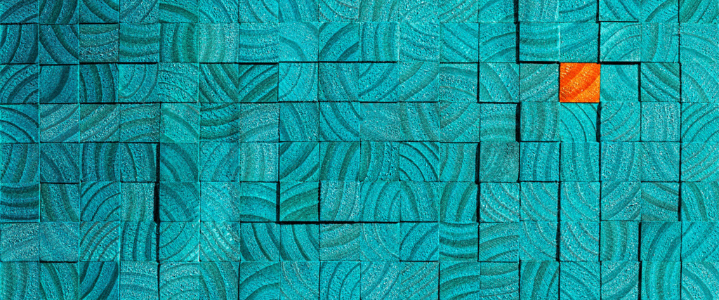 A grid of teal, patterned rectangular tiles covers the image, with one tile in the upper right corner colored bright orange, standing out from the rest.