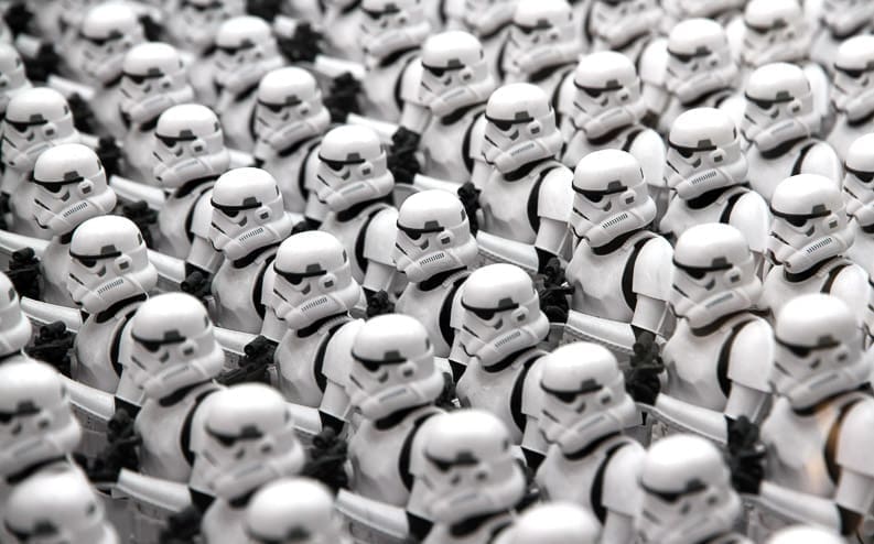 A large group of Star Wars Stormtrooper figures arranged in neat rows, all facing forward in identical white armor and helmets.