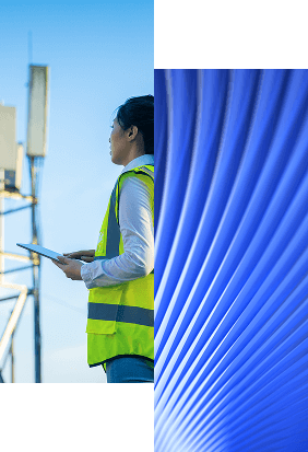 A person in a yellow safety vest holds a tablet and stands near a telecom tower, beside an abstract blue pattern with curved lines, highlighting the importance of Identity Management for Telecom operations.