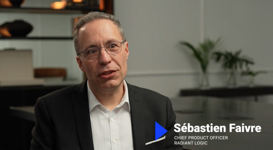 A man in a suit and glasses speaks in an office setting. Text on screen reads: Sébastien Faivre, Chief Product Officer, Radiant Logic.