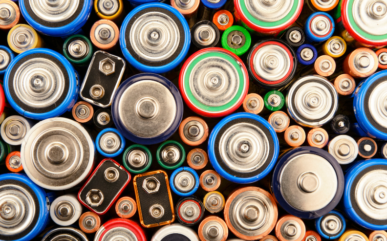 A close-up, top-down view of assorted batteries of various sizes, shapes, and colors—reflecting the energy and diversity that fuel how we drive organizations’ digital transformation efforts.