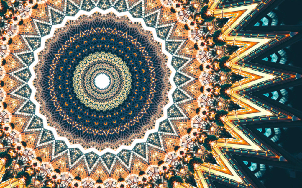 A vibrant kaleidoscopic pattern featuring concentric circles and zigzag shapes in yellow, orange, blue, and white, radiating outward in a symmetrical, geometric, and visually intricate design.